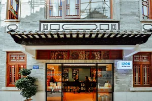 An exterior view of a traditional storefront with a sign that reads '1200 book&bed'.