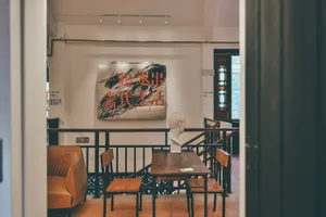 A cozy coffee shop interior featuring wooden furniture and a sign with Chinese characters on the wall.