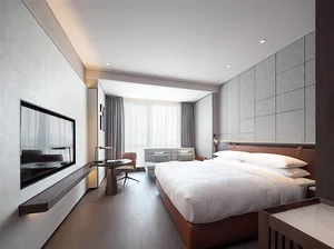 Modern minimalist bedroom with white bed, wooden floor, and beige curtains.