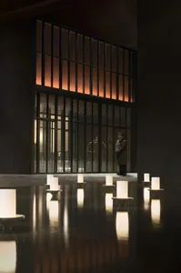 A minimalist lobby featuring dark wood, glass, and concrete materials