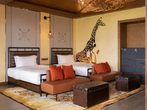Bedroom interior with modern design featuring fabric beds and wooden furniture.