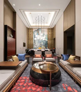 Well-designed hotel lounge featuring modern furniture, wooden accents, and textile upholstery, with a central coffee table.