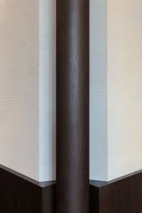 A close-up view of a modern interior design featuring dark wood-paneled walls with a textured surface.
