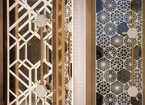Modern elevator doors featuring intricate patterned glass and metallic elements