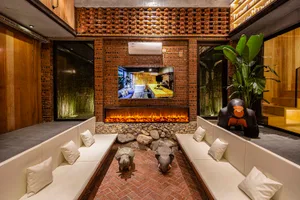 A cozy industrial-style living room with brick walls, a fireplace, and comfortable seating.