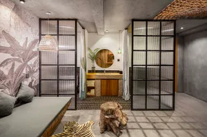 A modern industrial hotel suite featuring a concrete floor with a grid pattern, natural wood accents, and furniture designed 