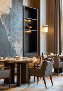 Modern restaurant interior with marble and wooden furniture, featuring a table set with cups and plates, and a hanging lanter