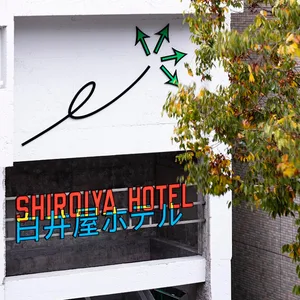 Modern hotel entrance featuring sign with metal frame and neon lights