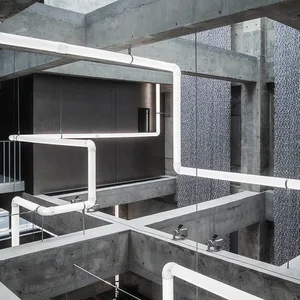Modern interior space featuring concrete pipes and minimalist design elements.