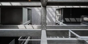 An overhead view of a minimalist office space with concrete walls and floors.