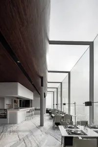 Modern minimalist restaurant interior with large glass windows and marble flooring.