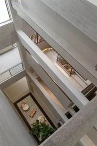 A modern hotel lobby with concrete walls, floors, and steps.