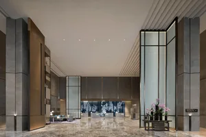 Modern hotel lobby featuring marble, glass, and metal materials and design.