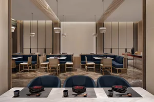 Modern restaurant interior with blue seating and wooden finishes.