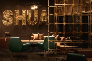 A modern industrial-style lobby featuring metallic decor and seating arrangements with leather accents.