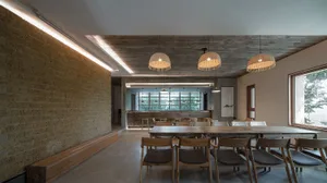 Industrial-themed restaurant interior with concrete walls, wooden furniture, and pendant lights.