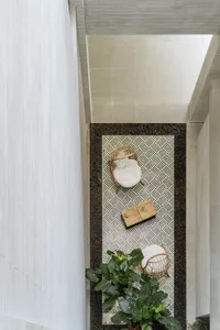 Minimalist living space decorated with wooden furniture, stone tiles, and woven fiber elements.