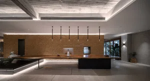 A minimalist office desk space with a wooden desk and hanging lights.
