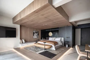 Modern bedroom featuring a bed with wood headboard, marble flooring, and metal accents.