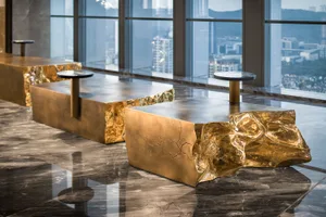 Modern coffee table made of metallic brass with a unique sculptural design.