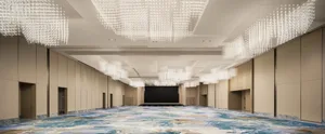 寬敞的會議廳採用現代設計，配有大型吊燈、天花板燈光以及中央舞台區域