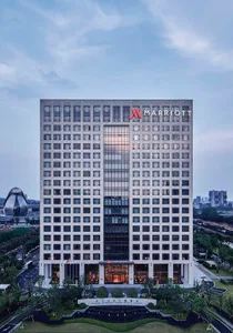 Modern hotel building exterior with glass windows and concrete cladding.