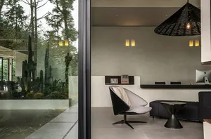 Modern interior living space with concrete and glass materials, featuring a minimalist design.