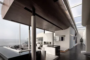 A modern living room featuring a contemporary design with a mix of materials and a panoramic view of the ocean.