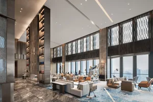 Modern lobby interior with polished concrete floor, marble accents, and contemporary furniture.