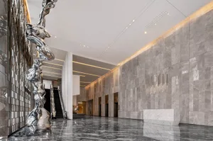 Modern lobby with marble finishes and sculptures.