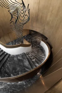 A modern staircase with marble steps and a circular design.