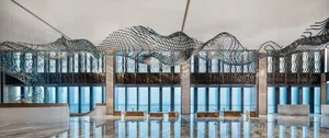 A modern lobby interior featuring a large, intricate metal sculpture