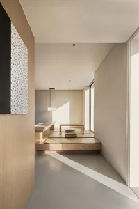A modern minimalist living space with wooden accents and beige tiles