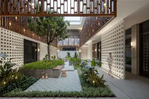 A modern residential living room featuring concrete elements and greenery.