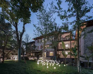 A modern residential house exterior with stone, brick, and aluminum materials.