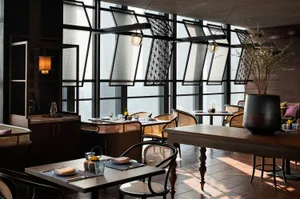 A modern restaurant interior with wooden furnishings and decorative elements.