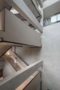 Modern, minimalist staircase with concrete walls and lighting in a contemporary architectural setting.