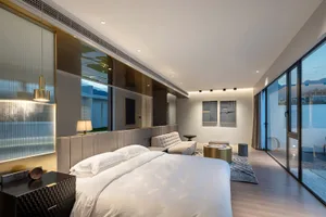 A modern luxurious bedroom suite with marble flooring and large windows.