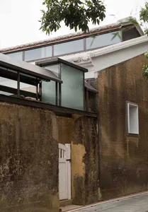Modern building exterior with concrete walls and large glass windows.