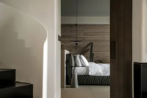 A modern bedroom with brown wooden walls and a minimalist bed setup.