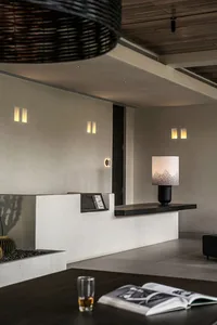 A modern living room with concrete surfaces, minimalist decor, and a warm, inviting atmosphere.