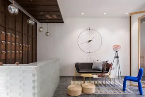 Modern hotel lobby with concrete flooring, minimalistic furniture, and sleek design features.