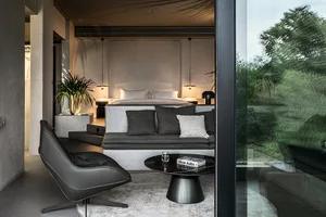 Modern industrial bedroom featuring concrete walls and minimalist furniture.