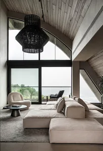 A modern living room featuring concrete, wooden elements, and fabric furniture