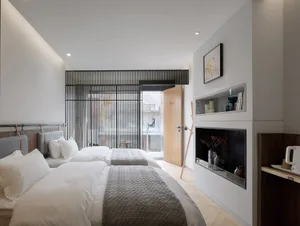 A modern minimalist hotel room with wooden furniture, metal accents, and glass doors.