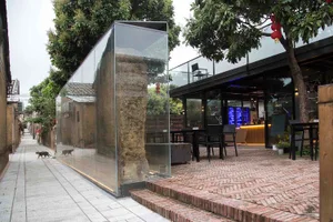 Outdoor cafe with modern design elements, glass walls, and stone accents.