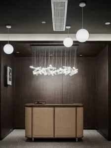 A modern reception desk with wooden, cane-inlaid panels, steel accents, and decorative lighting fixtures.