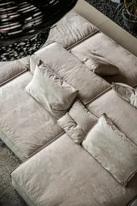 Plush, light gray fabric sofa adorned with multiple cushions in a modern design.