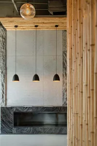 An office lounge area with bamboo walls and a marble fireplace.