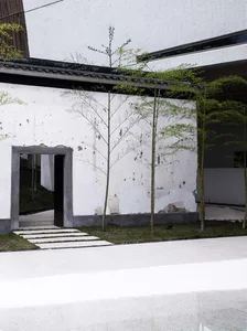 A minimalist front entry courtyard featuring concrete and bamboo elements.